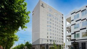 a tall white building next to two buildings at GRIDS Premium Hotel Otaru - Vacation STAY 68532v in Otaru