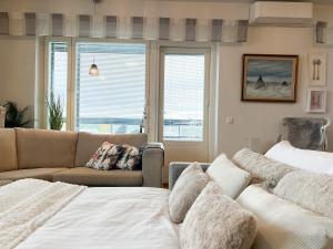 uma sala de estar com uma cama, um sofá e janelas em Aurora Penthouse em Rovaniemi