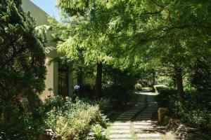 een tuin met bomen en een loopbrug naast een huis bij Yun Wu B&B in Renai