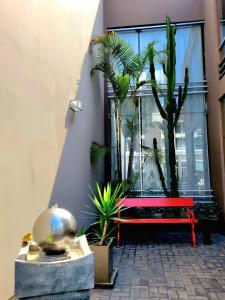 a red bench in front of a window with plants at 3B Barranco's - Chic and Basic - B&B in Lima