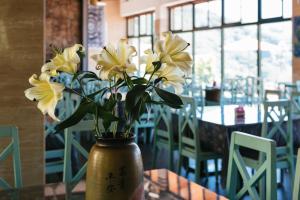 a vase filled with yellow flowers sitting on a table at Yun Wu B&B in Renai