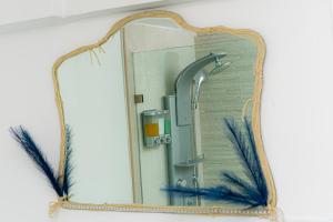 a mirror with a blue feather on a wall at Luxury 6BR Home in Brooklyn in Brooklyn