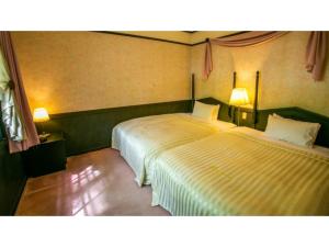 Dos camas en una habitación con dos lámparas. en Restaurant & Hotel Traumerei - Vacation STAY 47777v en Hakuba