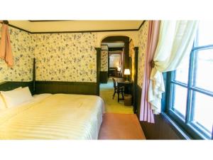 a bedroom with a bed and a window at Restaurant & Hotel Traumerei - Vacation STAY 47810v in Hakuba