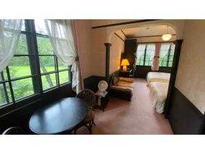 a bedroom with a bed and a table and window at Restaurant & Hotel Traumerei - Vacation STAY 47760v in Hakuba +45 photos