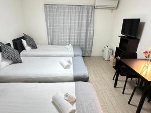 Pokój hotelowy z 2 łóżkami, biurkiem i telewizorem w obiekcie Kiyomizu Sannenzaka Home in Kyoto - Vacation STAY 33820v w mieście Kioto