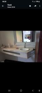 a bathroom with a sink and a mirror at Suite Dupla em Búzios in Búzios