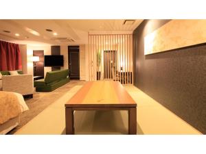 ein Wohnzimmer mit einem Tisch in der Mitte eines Zimmers in der Unterkunft Centurion Hotel Villa Suite Fukui Ekimae - Vacation STAY 34650v in Fukui