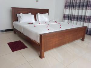 a bed with red roses on it in a room at Sea & Greens Apartments in Unawatuna