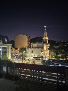 uma vista de uma cidade à noite com uma igreja em Várzea Palace Hotel em Teresópolis