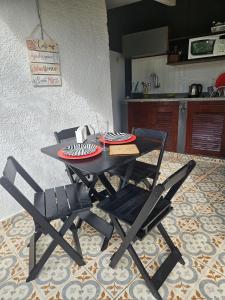 Suíte 1 no centro de Búzios في بوزيوس: طاولة سوداء وكراسي في مطبخ