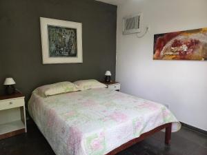 una camera con un letto e due comodini con lampade di Suíte 1 no centro de Búzios a Búzios