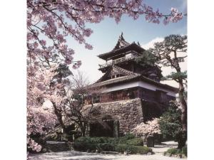 Centurion Hotel Villa Suite Fukui Ekimae - Vacation STAY 34532v في فوكوي: معبد في وسط حديقة مع أشجار اكورا