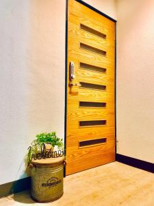 a wooden door with a potted plant in front of it at Kawamura Building 3F - Vacation STAY 47042v in Kusatsu