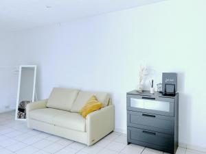 a living room with a white couch and a dresser at les Jardiniers in Strasbourg