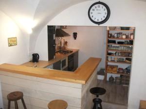 a kitchen with a counter and a clock on the wall at Volca'séjour in Orcines
