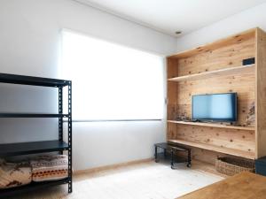 富士吉田的住宿－urban"s camp fuji - Vacation STAY 54448v，一间卧室设有木墙和电视。