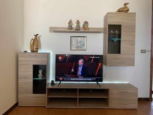 TV de pantalla plana en un centro de entretenimiento de madera en Villa Mediterranean Sunset en Punta Braccetto