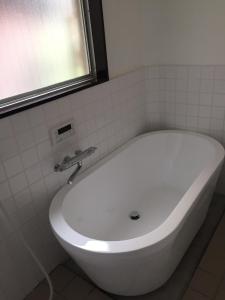 a white bath tub in a bathroom with a window at Maison dEssence - Vacation STAY 52767v in Izu