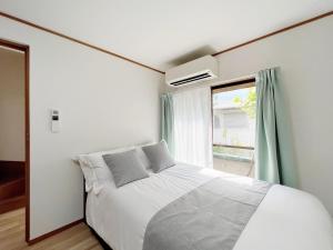 a bedroom with a white bed and a window at Senmagawa - Kuhoji - Vacation STAY 15376 in Yaochō