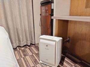 un piccolo apparecchio bianco seduto sul pavimento in una stanza di Hotel Grand View Takasaki - Vacation STAY 55422v a Takasaki