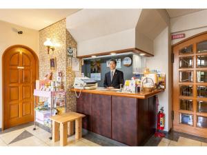 a man sitting at a counter in a kitchen at Business Hotel Katsuya - Vacation STAY 62201v in Wakayama