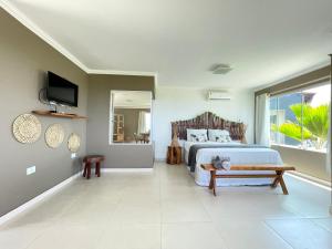 a bedroom with a bed and a television in it at Chalés Alto dos Milagres in São Miguel dos Milagres