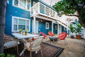 a patio with a table and chairs in front of a blue building at Charming Historic Apartment Mins to Convention Center, Beaches and Downtown Attractions in Long Beach