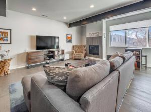 a large living room with a couch and a tv at Roof Top Deck w Views Walk to Empower Field in Denver