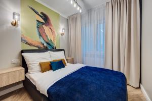 a bedroom with a king sized bed with a bird painting on the wall at NOVA L-Elite in Szczecin