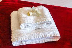 Una toalla blanca con una botella encima. en Fonte da Rosa Guest House, en Belmonte