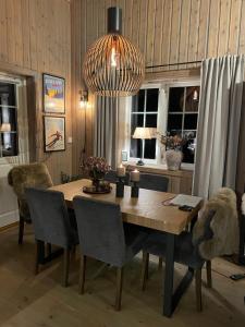 mesa de comedor con sillas y lámpara de araña en Leilighet i vakre Rauland, en Rauland