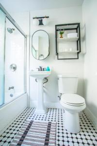y baño con aseo, lavabo y espejo. en Charming Historic Apartment Mins to Convention Center, Beaches and Downtown Attractions en Long Beach