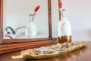 un tavolo con specchio e un vaso con fiori di Fonte da Rosa Guest House a Belmonte