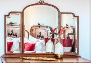 Un espejo en una mesa con jarrones. en Fonte da Rosa Guest House, en Belmonte