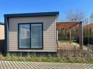 a small house with a porch and a wooden deck at Moderne chalet met airco in Blankenberge in Blankenberge