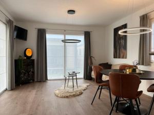 a living room with a dining room table and chairs at Moderne chalet met airco in Blankenberge in Blankenberge