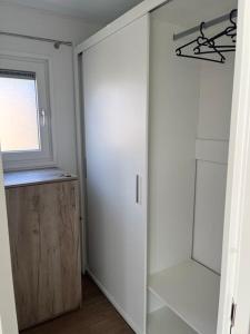 een kamer met een kast met een deur en een raam bij Moderne chalet met airco in Blankenberge in Blankenberge