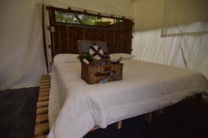 - un lit dans une tente avec un panier en osier dans l'établissement Eco-Glamping Panorama, à Monterrey
