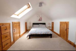 a bedroom with a bed with wooden cabinets and a skylight at Anne’s House in Dunfanaghy