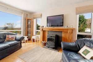 a living room with a fireplace and a flat screen tv at Anne’s House in Dunfanaghy