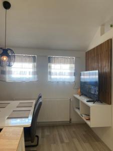 ein Wohnzimmer mit einem Schreibtisch und einem TV in der Unterkunft Albert apartments Zagreb airport in Velika Gorica