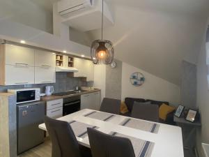 eine Küche und ein Wohnzimmer mit einem Tisch und Stühlen in der Unterkunft Albert apartments Zagreb airport in Velika Gorica