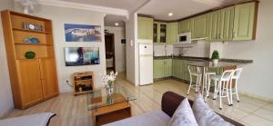 een woonkamer met een bank en een keuken met groene kasten bij Apartamento La Marisma in Puerto de Mogán