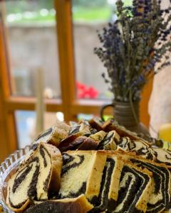 a loaf of bread on a table with a vase of flowers at Casa Chira in Vişeu de Sus