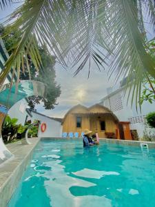 une personne assise à l'eau dans une piscine dans l'établissement Villa Motel Mas Guesthouse, à Batang Berjuntai