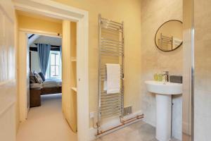 uma casa de banho com um lavatório e um espelho em Josua Medieval Living Maldon em Maldon