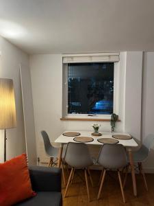 sala de estar con mesa con sillas y ventana en Heart of Covent Garden central apartment - 2 bed en Londres