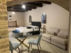 1 dormitorio con cama, sofá y mesa en Residenza il Duomo, en Nocera Umbra