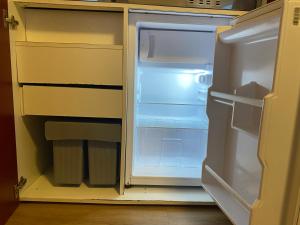 an empty refrigerator with its door open in a kitchen at LUX Apartments in Mörfelden-Walldorf